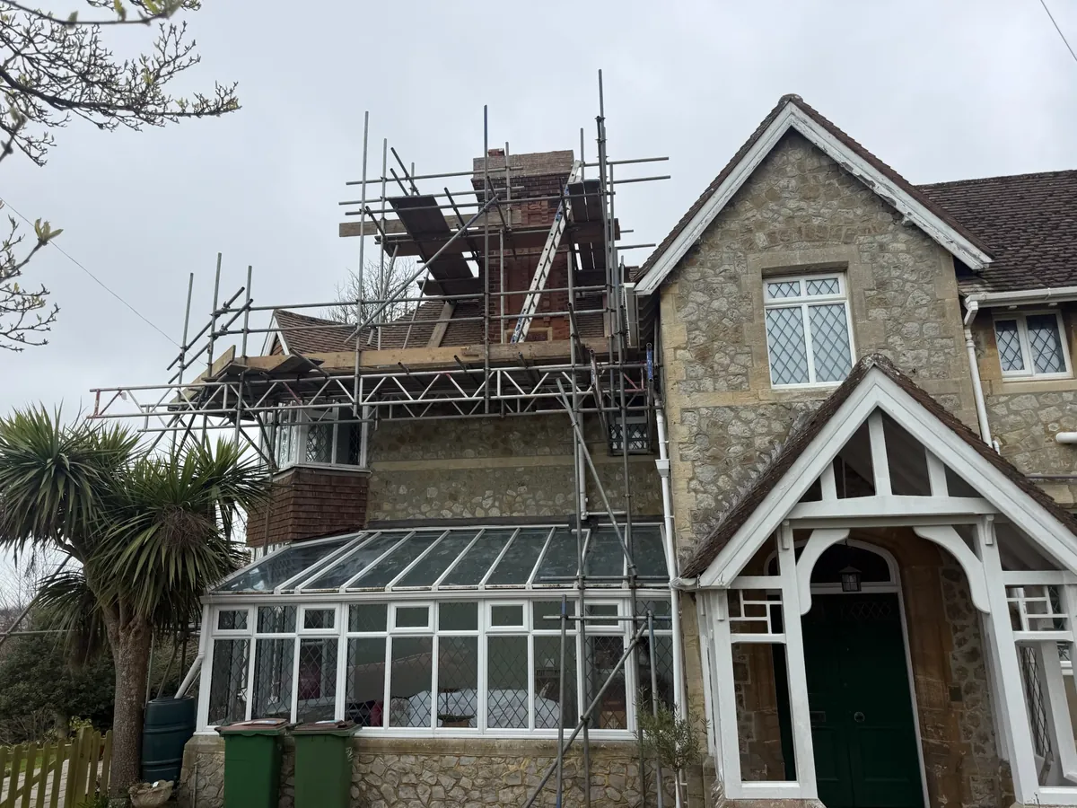 Scaffolding around the chimney on a stone house in Hythe
