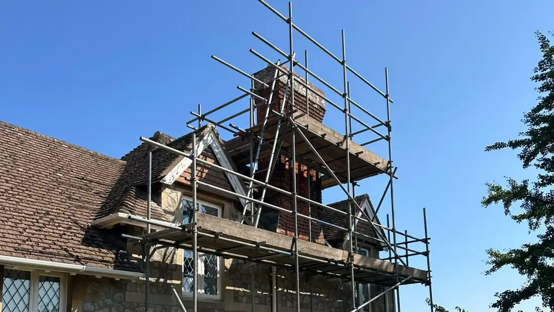 Repointed brick chimney and clay tiled roof on a Hythe house