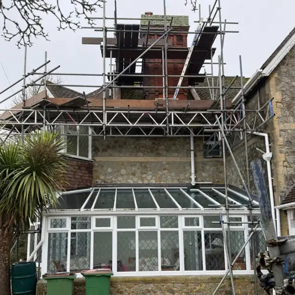 Rear of the same Hythe house with scaffold up to the chimney for repointing